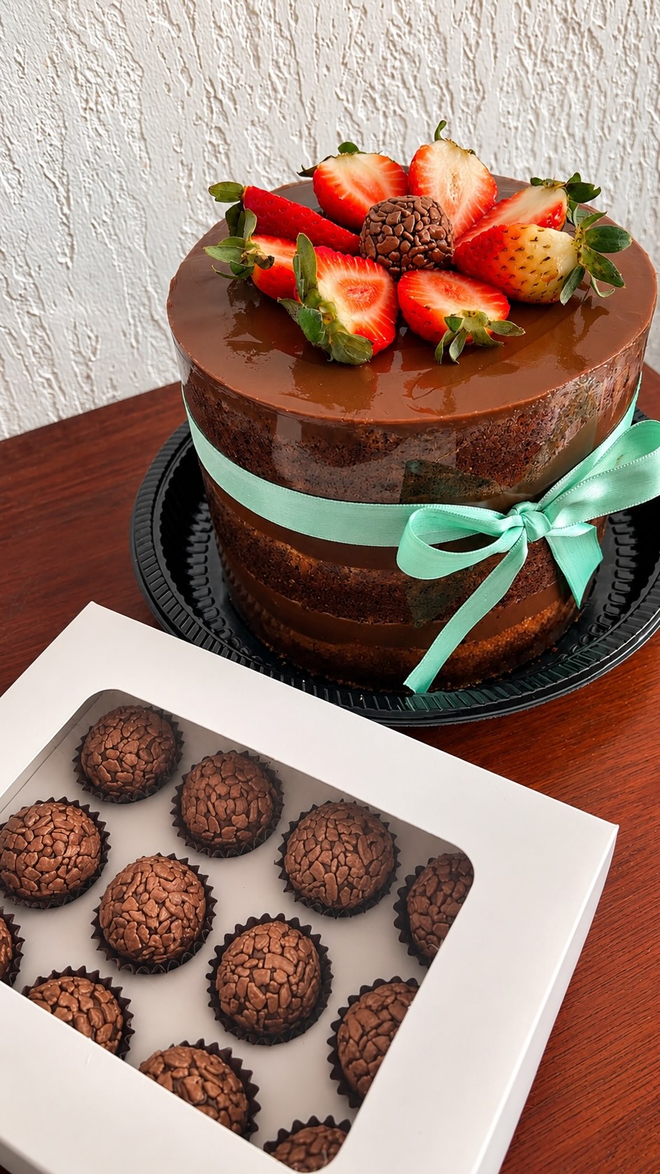 Bolo de chocolate decorado com morangos e brigadeiros